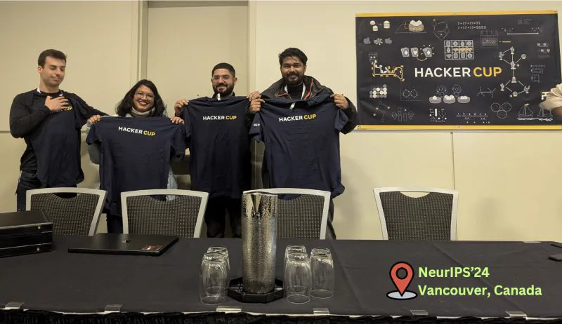 The AlgoUniversity R&D team holding Meta HackerCup shirts at NeurIPS 2024 in Vancouver