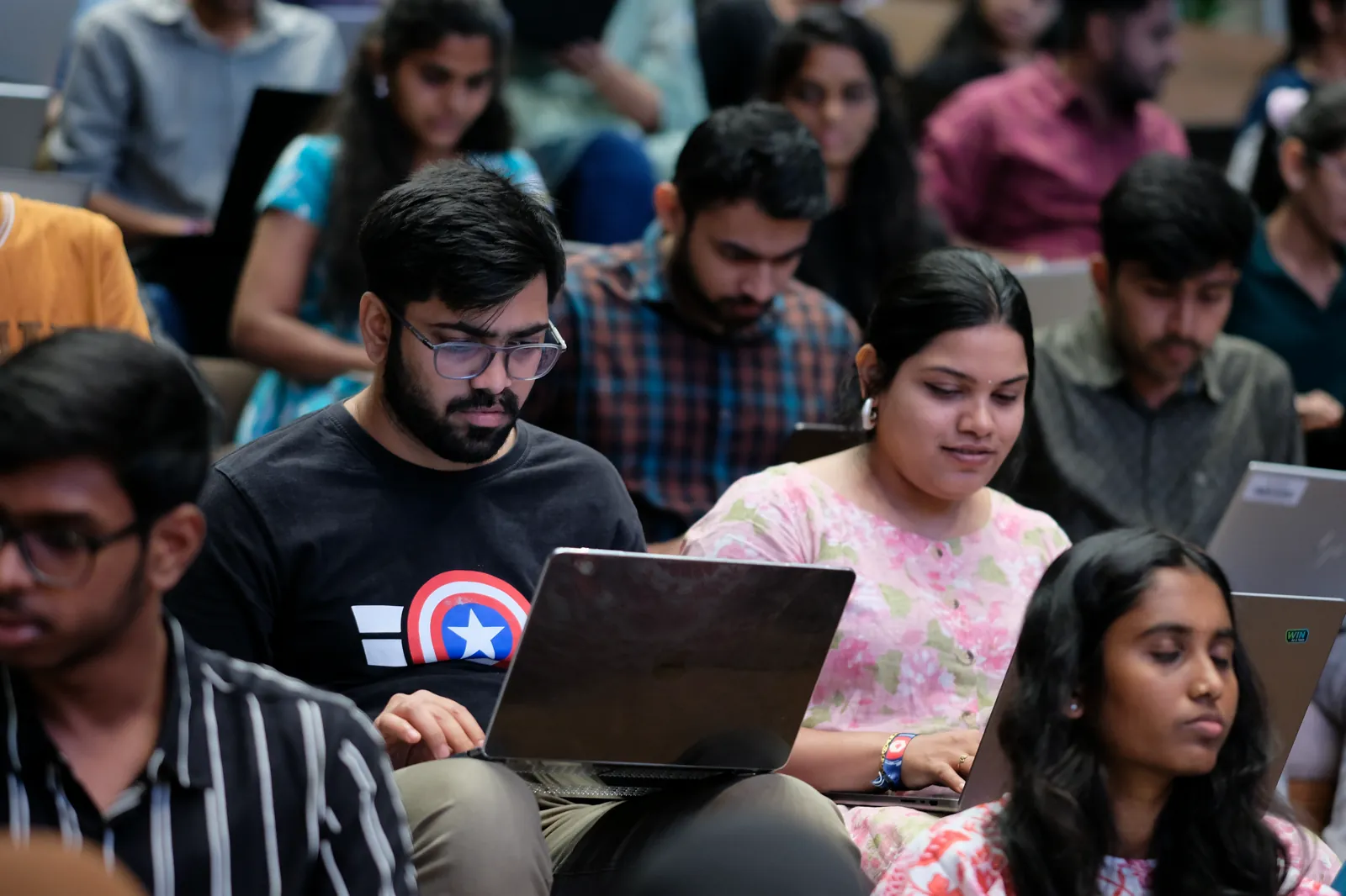 AlgoUniversity students coding on their laptops during a live classroom session