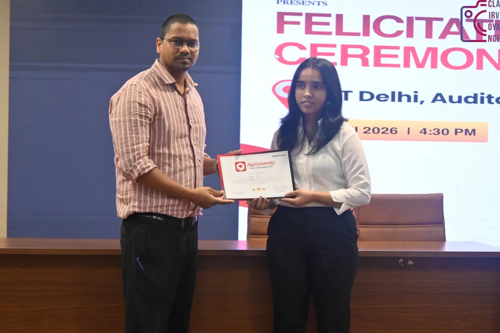 An AlgoUniversity representative presenting an ATF certificate to a fellow on stage at the NIT Delhi felicitation ceremony, under the ceremony banner