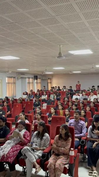 Rows of seated students and guests in a hall during a felicitation ceremony