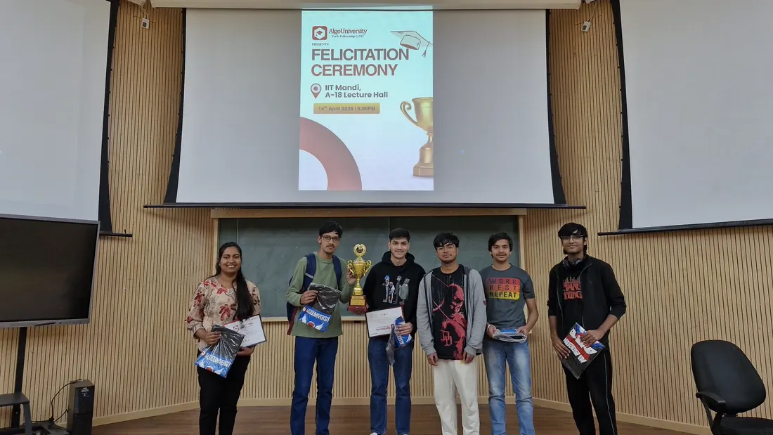 ATF fellows standing with their trophy and goodie bags at the IIT Mandi felicitation ceremony, under a slide naming the A-18 Lecture Hall