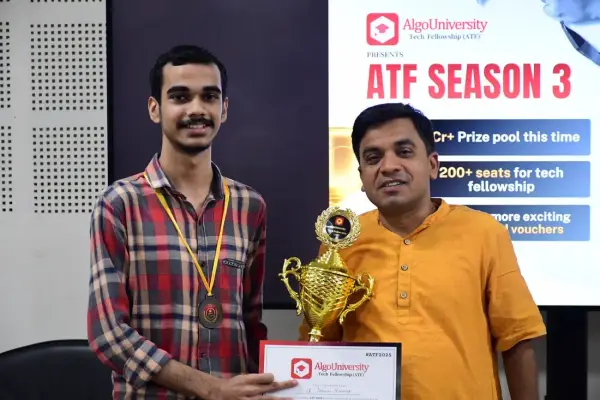An ATF fellow holding a trophy and certificate beside a faculty member, in front of an ATF Season 3 banner