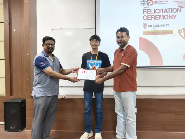 An ATF fellow receiving his certificate from two faculty members at the RGIPT felicitation ceremony, under the ceremony slide