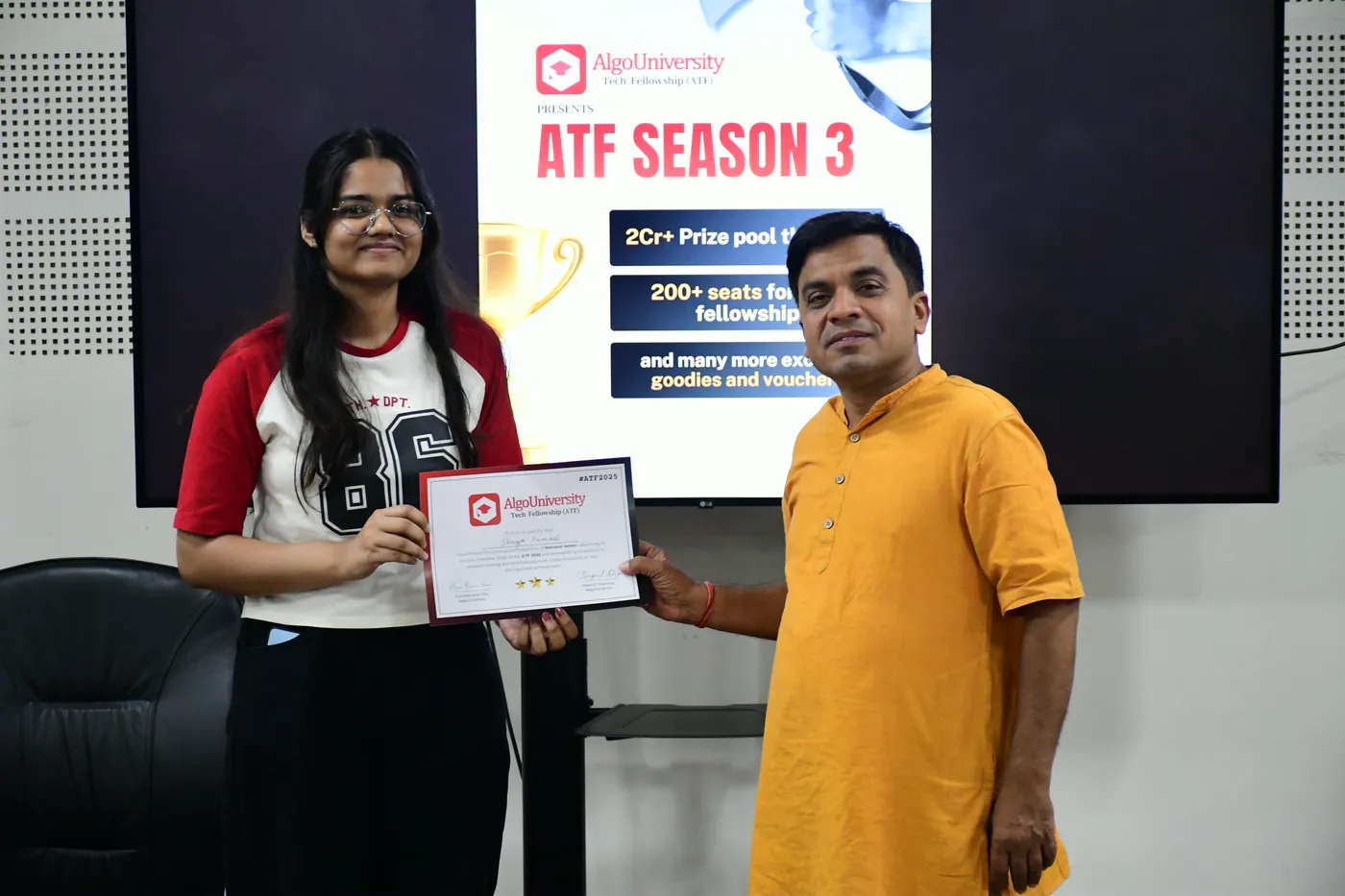 An ATF fellow receiving her certificate from a faculty member in front of an ATF Season 3 banner